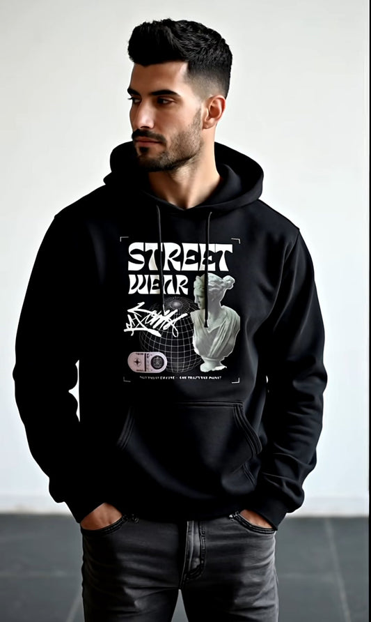 Man wearing a black hoodie with graphic design on a plain background
