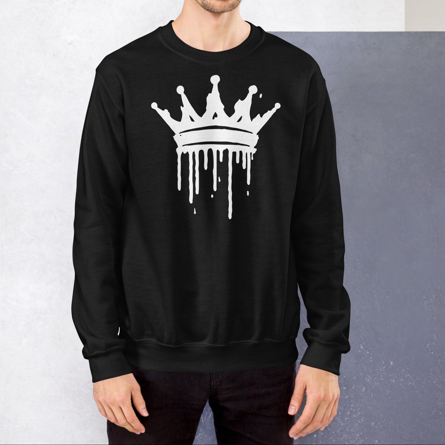 Man wearing a black sweatshirt with a white crown design against a gray background