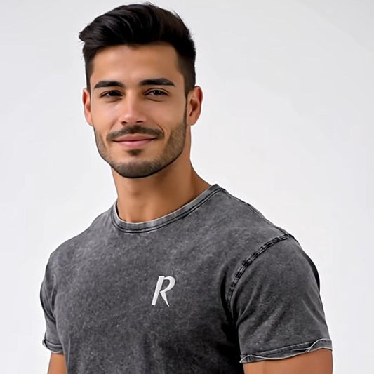 Man wearing a dark gray t-shirt with a white logo on a white background