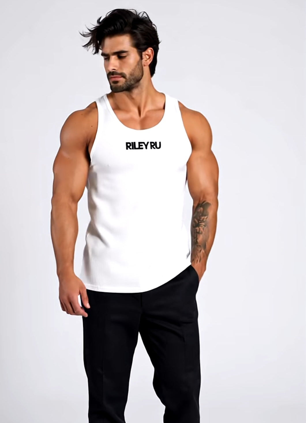Man wearing a white tank top with 'RILEY RU' text on a plain background