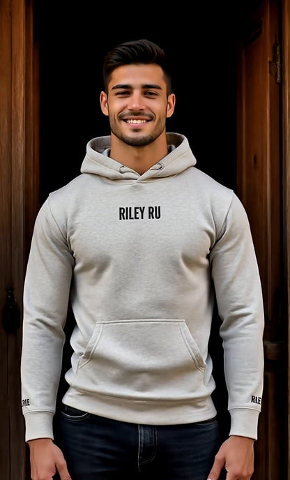 Man wearing a gray hoodie with 'RILEY RU' branding against a dark background