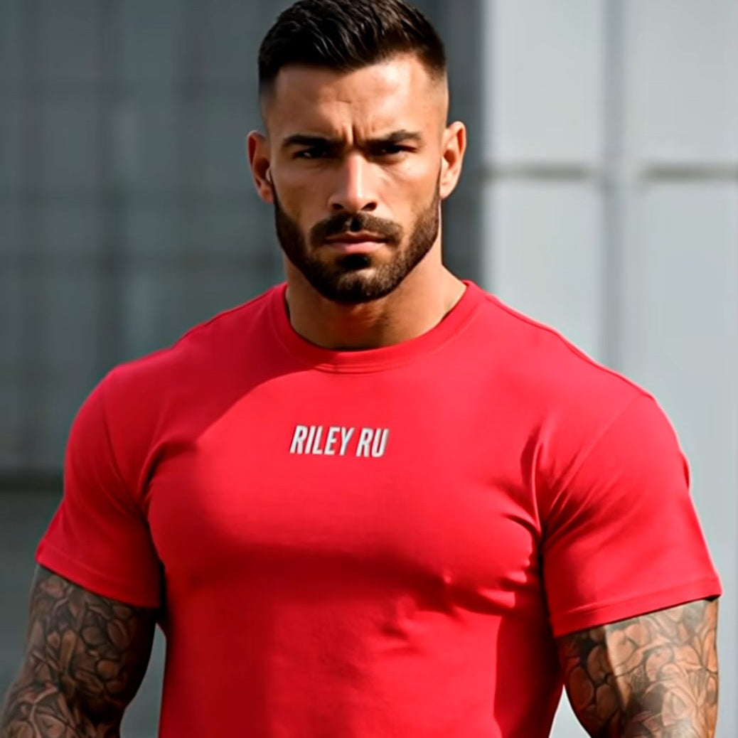Man wearing a red t-shirt with 'Riley RU' text, standing against a neutral background