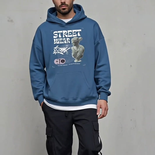 Man wearing a blue hoodie with graphic design against a plain background