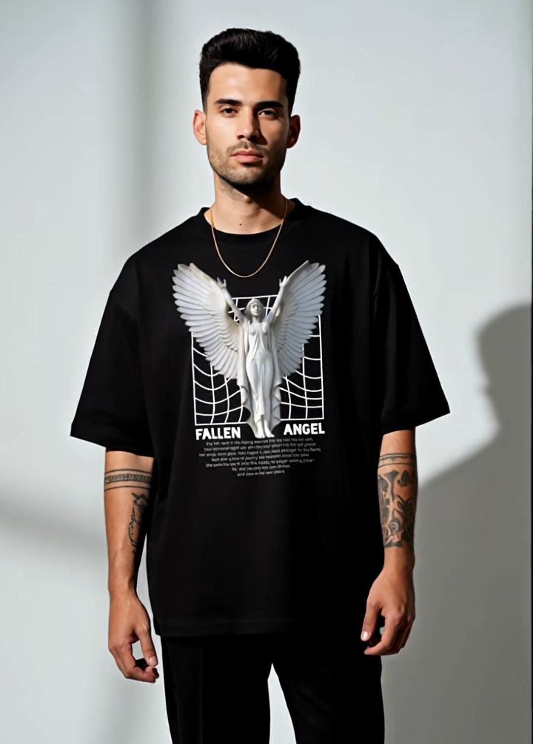 Man wearing a black t-shirt with graphic design on a plain background