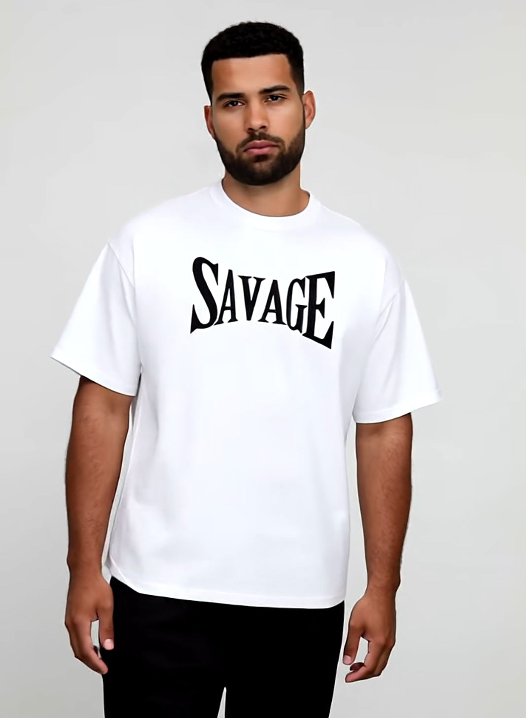 Man wearing a white t-shirt with 'SAVAGE' printed on it against a plain background