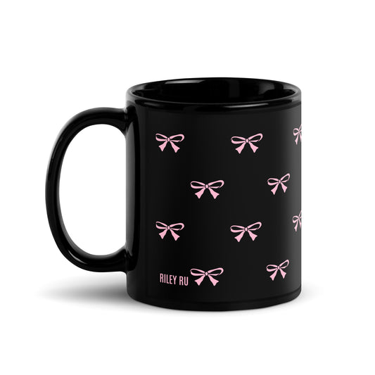 Black mug with pink bow patterns on a white background