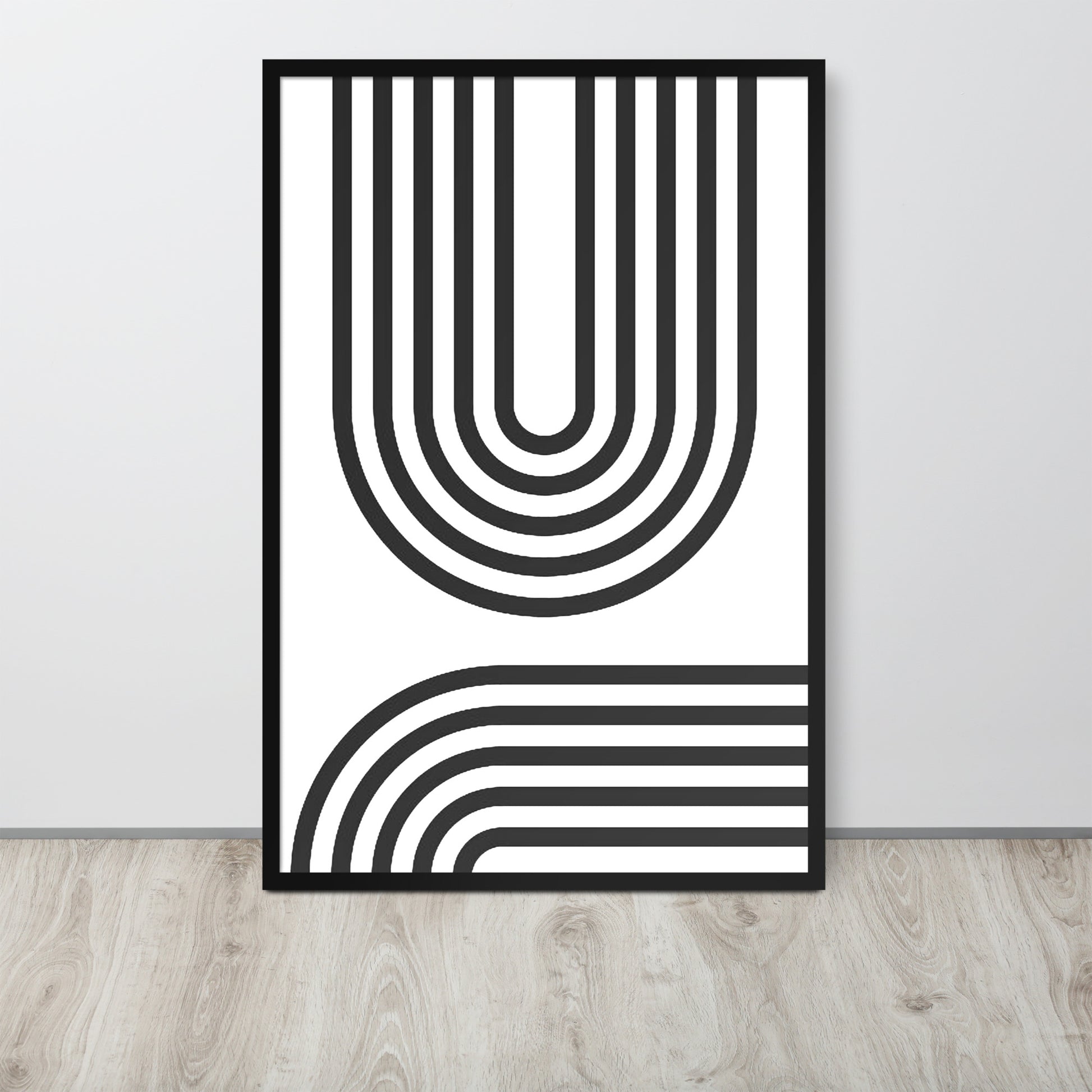 Framed black and white abstract art print on a light gray wall.