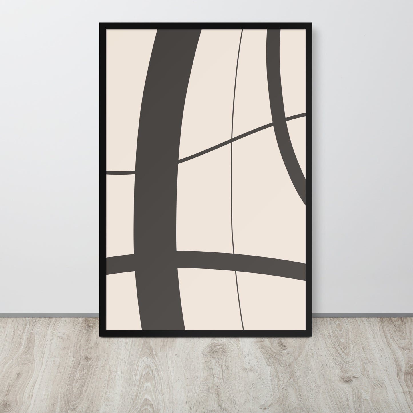 Abstract art print with black lines on a beige background in a black frame, hanging on a light gray wall.