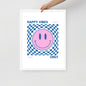 Framed poster with a pink smiley face and blue checkered pattern, text 'Happy Vibes Only' on a white background.
