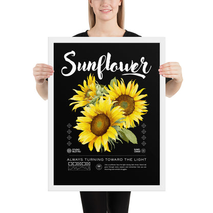 Person holding a framed poster with sunflowers and text on a black background