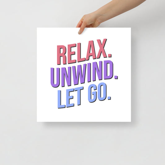 Hand holding a sign with 'Relax. Unwind. Let Go.' text on a plain background