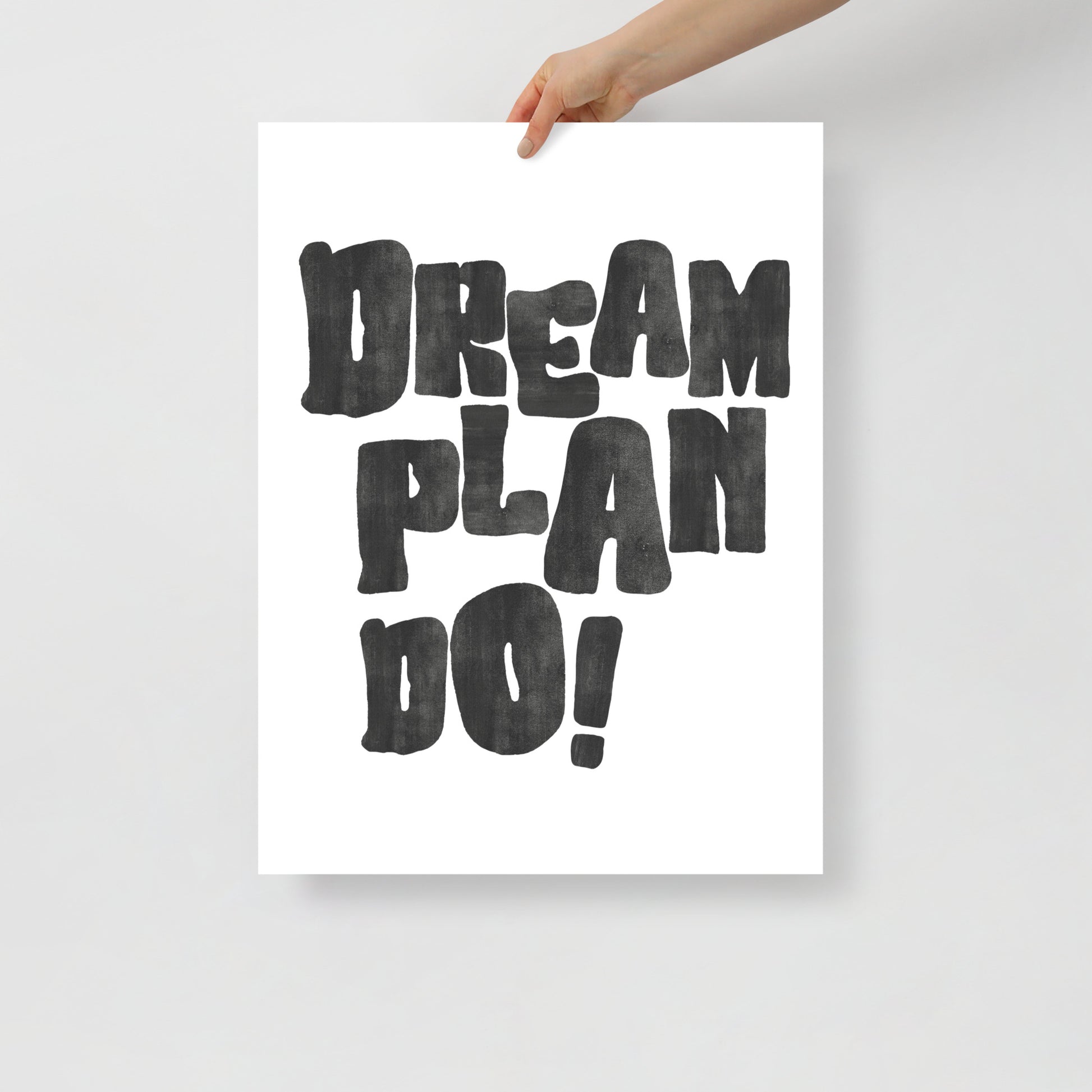 Poster with 'Dream Plan Do!' text held by a hand on a light gray background