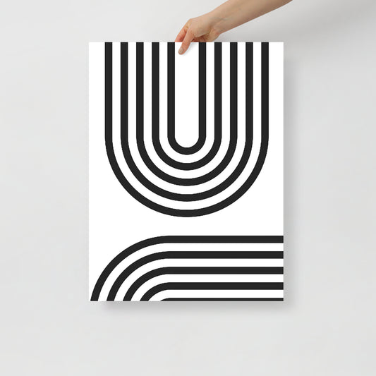 Poster with black and white geometric design held by a hand on a light gray background