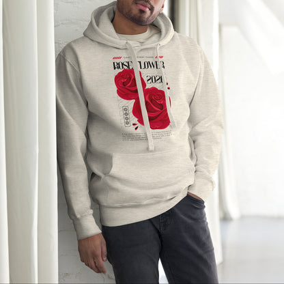Man wearing a beige hoodie with a red rose design indoors