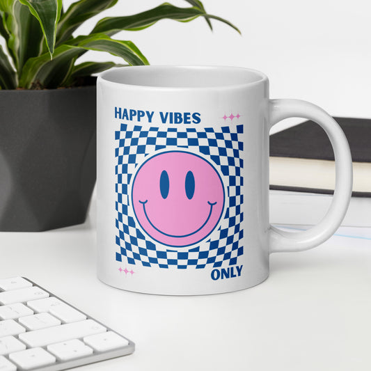 White mug with pink smiley face and text 'Happy Vibes Only' on a desk with a plant and keyboard.